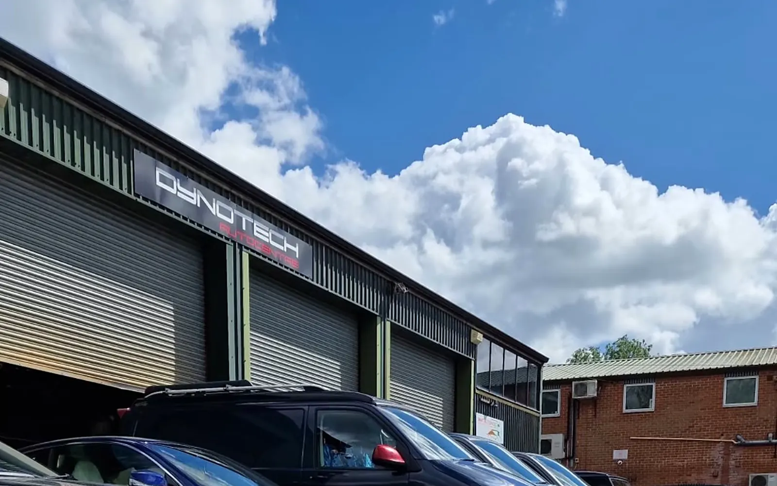 Our forecourt on the RAC Estate in Faringdon, with the DYNOTECH sign under a big blue sky