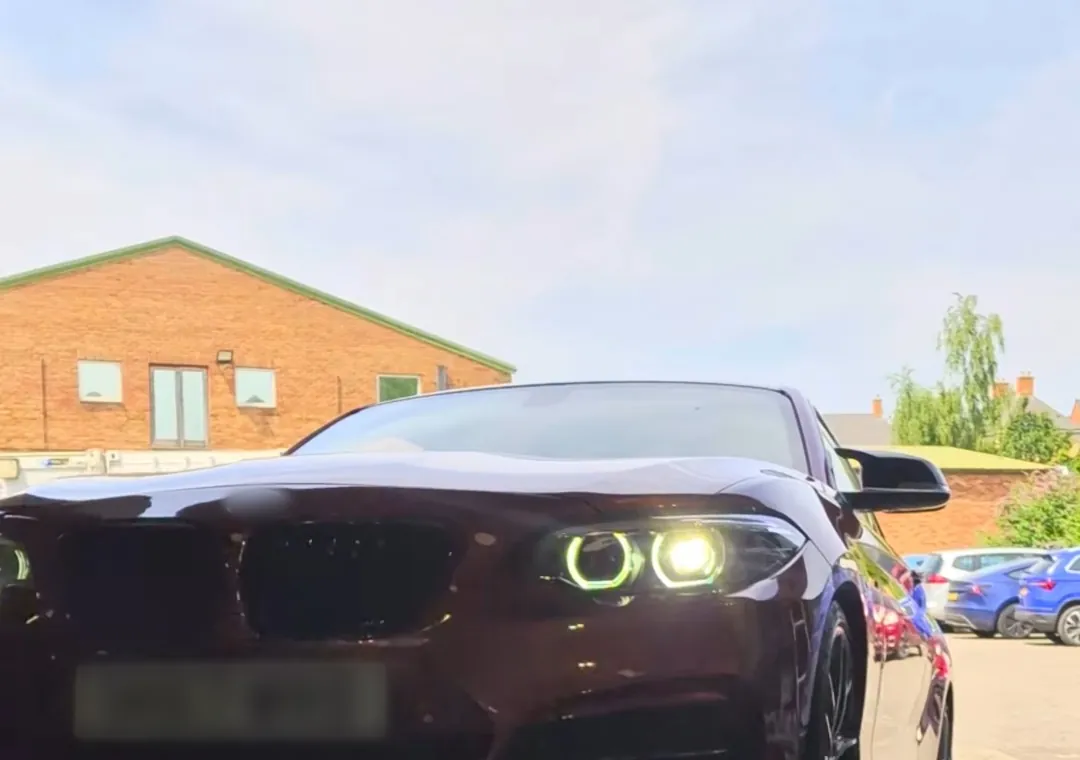A car on our rolling road with its headlights on
